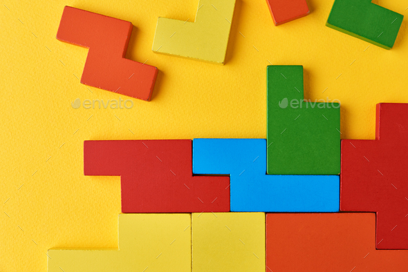 Different wooden blocks on yellow background. Concept of logical thinking and education