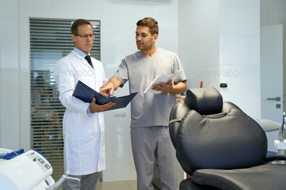 Two medical workers looking at papers in dental clinic