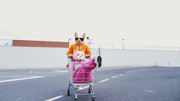 Pig man pushing bear woman in shopping cart, throwing confetti