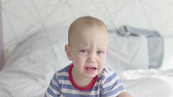 Cute Toddler Boy Child Sad Face Portrait Crying Moody Kid Sitting in Bed Daytime alt