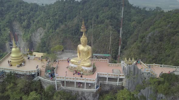 Aerial footage of Buddha on top of Tiger Cave Temple, Wat Thum Sua, stone rocks, Krabi, Thailand