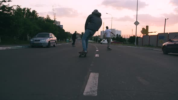 Group of Young People Skateboarding on the Road in the Early Morning Cinematic Shot Slow Motion alt
