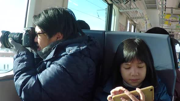 Asian Father Take A Photo From Window Train While Travel By Train With His Daughter alt