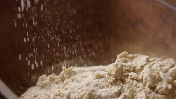BAKING - Sprinkling flour during sourdough bread baking, slow motion pan right alt