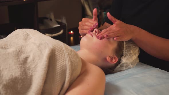 The Masseur Makes Hands with Cosmetic Oil Massage of the Face and Nose