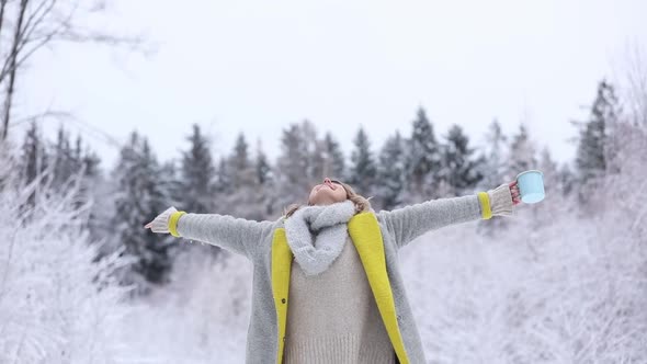 Beautiful happy woman in coat in a snow forest.