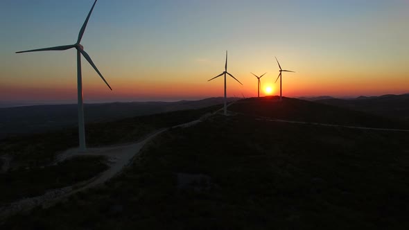Aerial view of windmills at beautiful colorful sunset alt