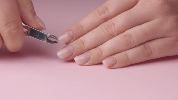 Closeup Woman Hand on Pink Makes Manicure for Herself