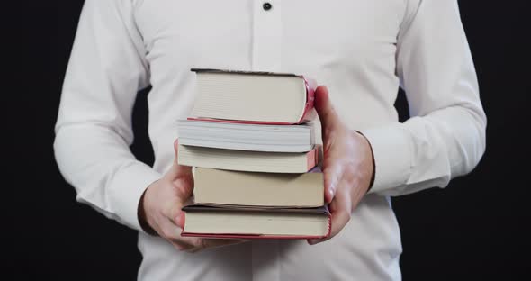 Person holding books in hands alt