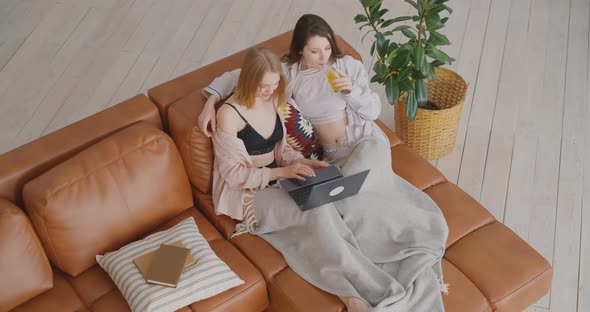 Two lesbians are on the couch Two lesbians are working on a laptop LGBT Bisexual Love alt