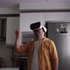 Young man walking around virtual market with vr glasses in kitchen. - VideoHive Item for Sale