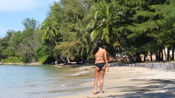 Back View of Young Sexy Asian Woman in Bikini Walking on the Calm Beach Alone alt