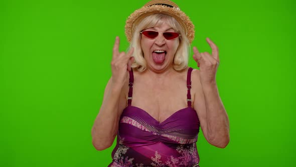 Senior Woman Tourist in Swimsuit Dancing Celebrating Showing Tongue Rock and Roll Hand Gesture alt