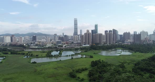 Rural green fields with fish ponds between Hong Kong and skylines of Shenzhen,China alt