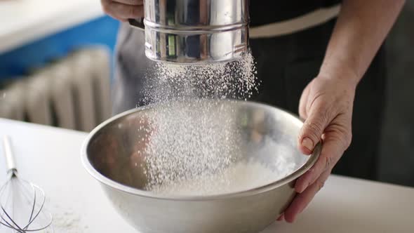 Woman Sifting Flour in a Bowl alt