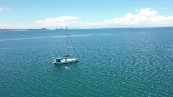 rotating aerial shot of a sail boat in a blue ocean off the coast of Madagascar alt