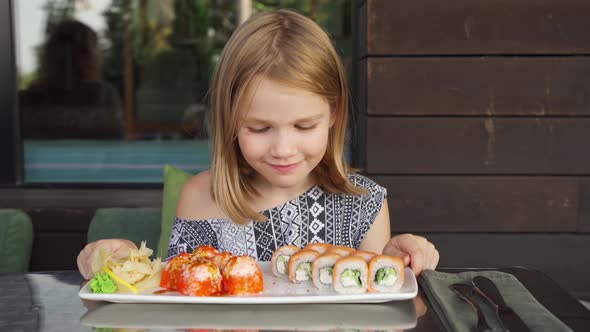 Little Girl in Cafe Restaurant Country House Smiles and Licks Looks Sushi Rolls alt