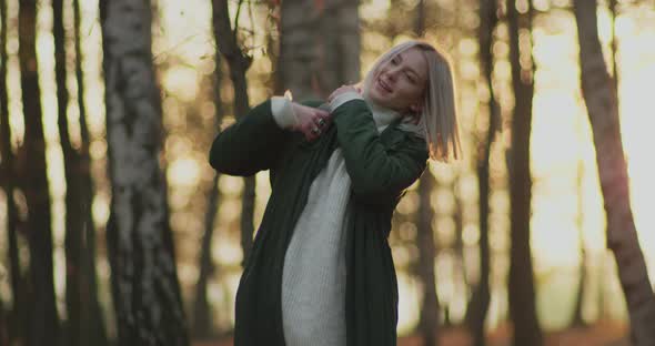 Beautiful Woman Picking Her Bag Up and Having Fun in the Middle of a Park in an Autumn Sunset alt