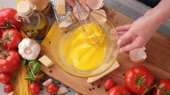 Making Pasta Carbonara  Mixing Egg Yolks in Glass Bowl By a Whisk alt
