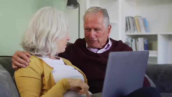 Senior caucasian couple using laptop computer together alt