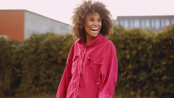 Young Woman With Afro Hair Laughing In Pink Clothes alt