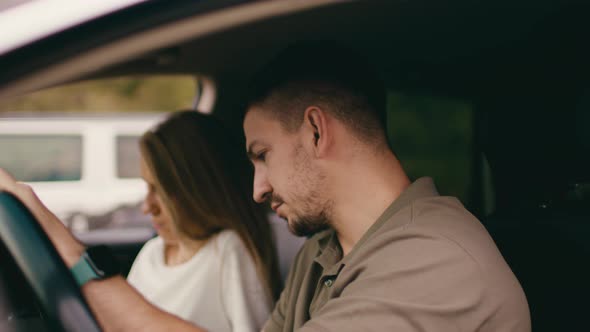 Young Couple Sitting in a Car with Open Windows View From the Inside