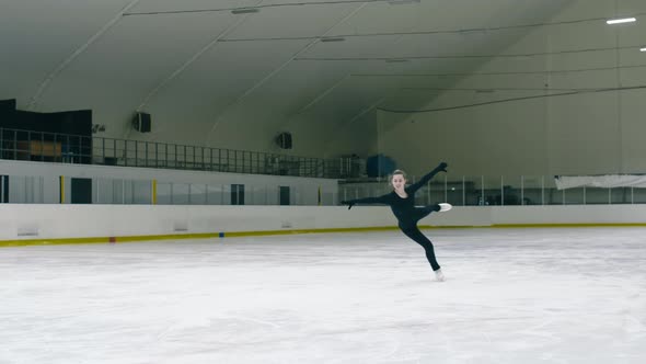 Young woman skating and jumping on ice rink