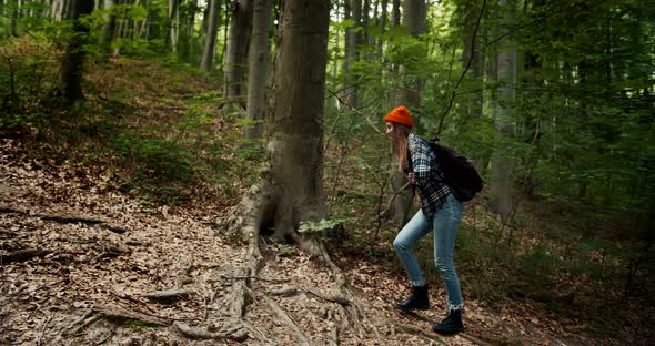 Woman Walking Uphill in Forest