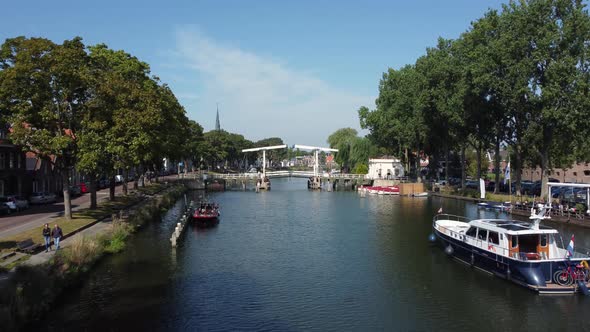 A pleasure boat sails up the Vecht towards a bridge at Weesp in Netherlands alt