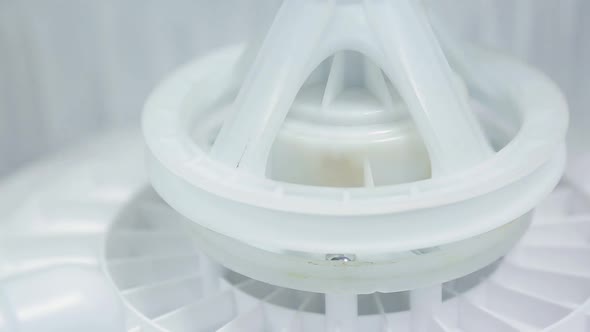 worker assembles a semi-automatic washing machine alt