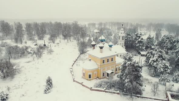 Festive Winter Village Landscape with Wooden Houses and a Church Aerial View alt