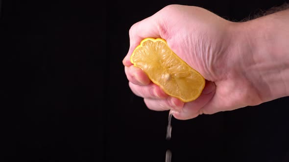 Close-up of a lemon. hand squeezes of lemon juice