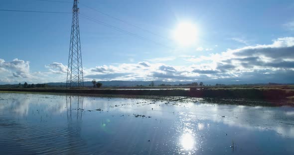 Side Aerial View Flooded Rice Agricultural Rural Fields with Electric Line Pylon