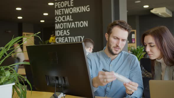 Male Engineer Showing Detail to Female Colleague