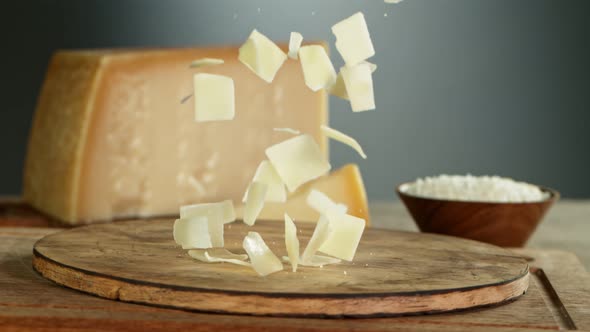 Super Slow Motion Shot of Parmesan Shavings Falling on Wooden Board at 1000 Fps alt