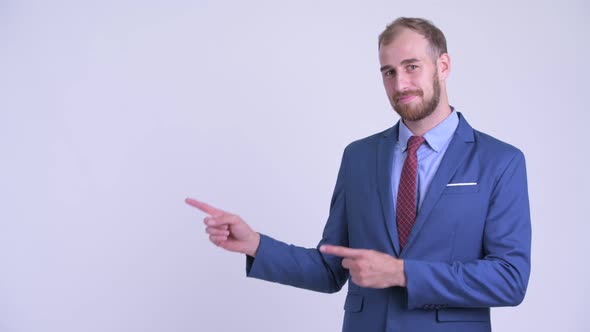 Happy Bearded Businessman Pointing To the Side
