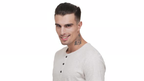 Halfturn Portrait of Handsome Smiling Guy with Bristle and Tattoo on Neck Posing on Camera with alt