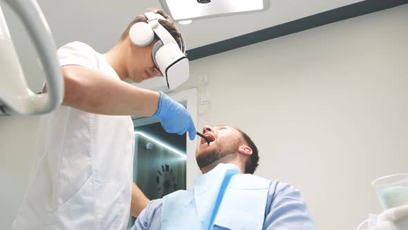 Dentist Who Uses New Technology of Dental Treatment with the Help of Virtual Reality Glasses alt