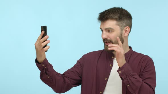 Slow Motion of Handsome Modern Guy in Casual Clothes Having Video Chat on Smartphone App Waving Hand