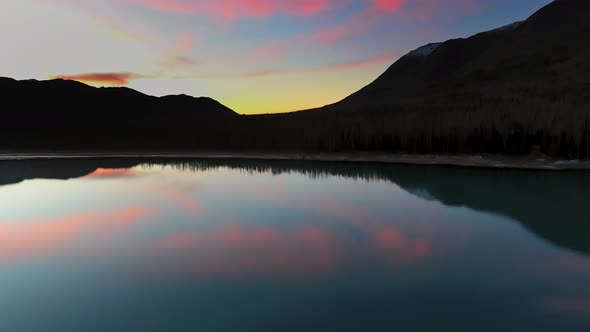 Drone captures the reflection of clouds in a lake near a mountain in Eklutna Lake, Alaska, USA alt