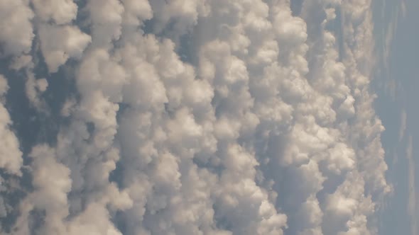 Fluffy Clouds From Above While Flying in a Plane alt