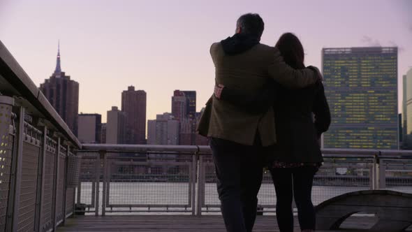 Couple in New York City walk down pier