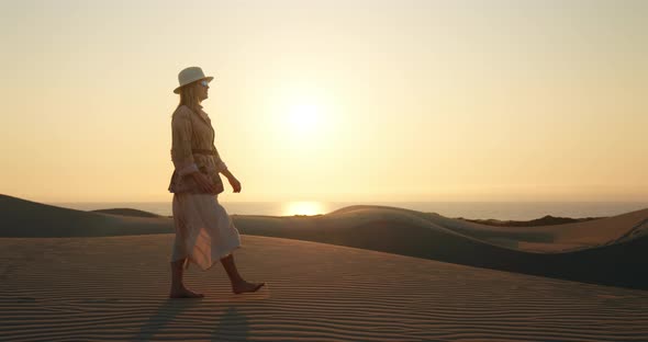 Lonely Girl Walking Barefoot on Rippled Sand Dune in Desert alt