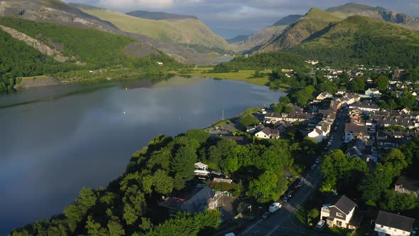 Tilt Up Reveal of Touristic Lakeside Village in European Mountains in Wales - Aerial Drone alt