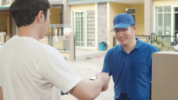 Young postal delivery courier man holding parcel boxes for sending to customer. alt