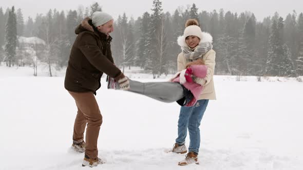 Parents Swaying Child in Winter Park alt