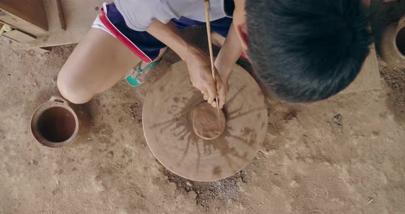 Asian Man Working On Pottery Wheel alt