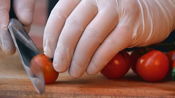 Cutting Tomato Behind Fresh Vegetables
