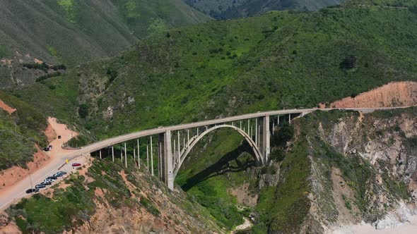 Aerial drone of Bixby Creek Bridge alongside the long Route 1 coastal road of Big Sur California on alt