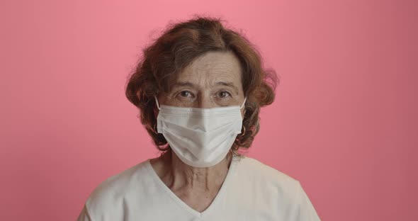 Senior Woman Looking Straight at Camera Wearing Surgical Protection Mask alt